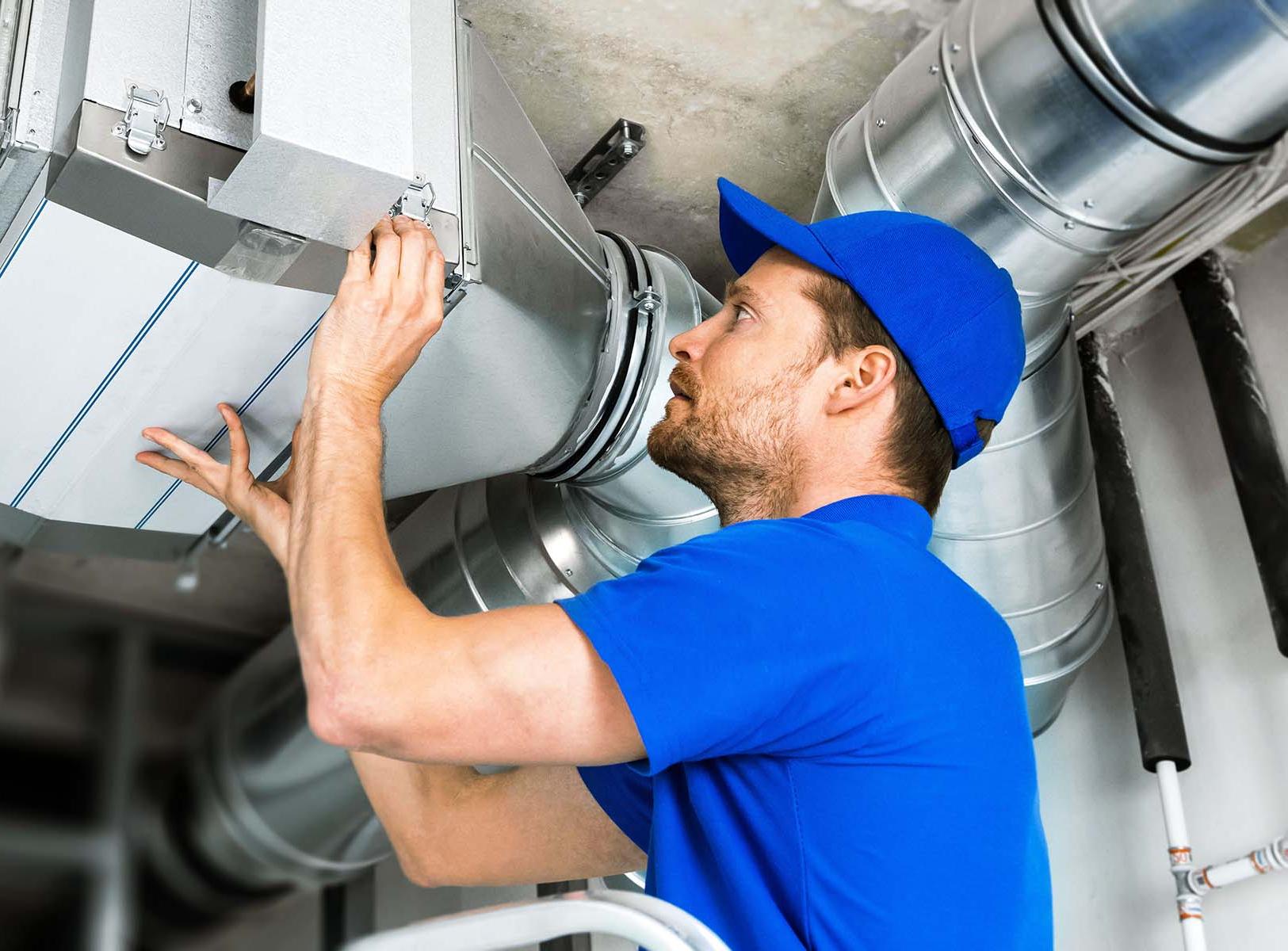 Technician working on industrial air ducts.